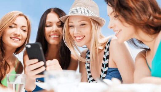 a group of women looking at a cell phone